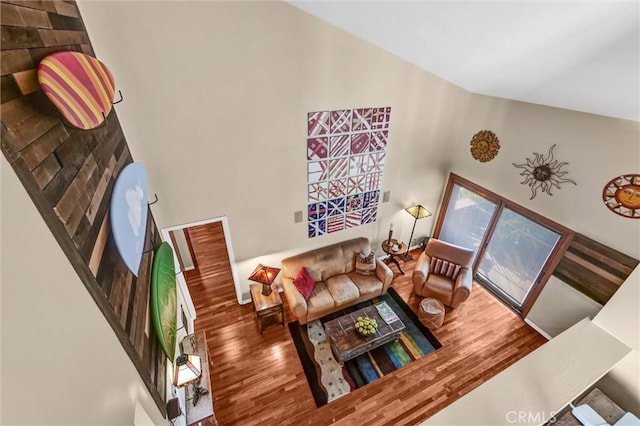 living area with wood finished floors and high vaulted ceiling