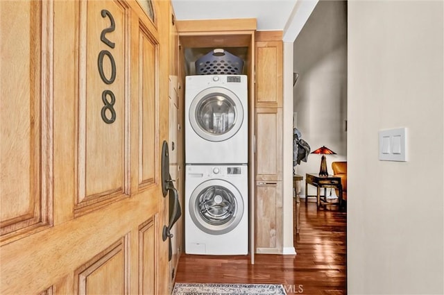 washroom featuring laundry area, wood finished floors, and stacked washer / drying machine