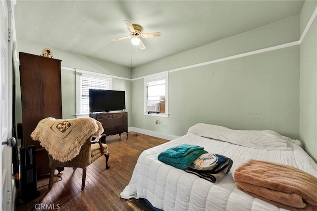 bedroom with cooling unit, a ceiling fan, baseboards, and wood-type flooring