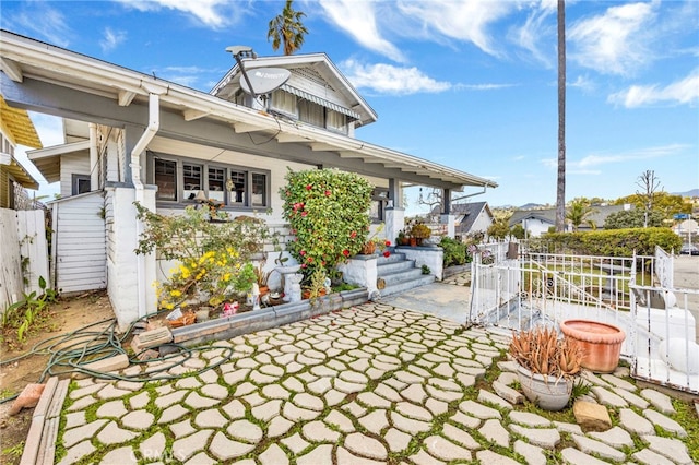 view of front of home featuring a patio and fence