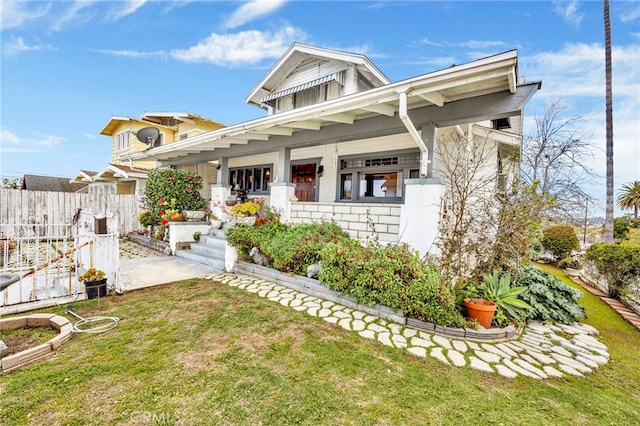 view of front facade with a porch, fence, and a front yard