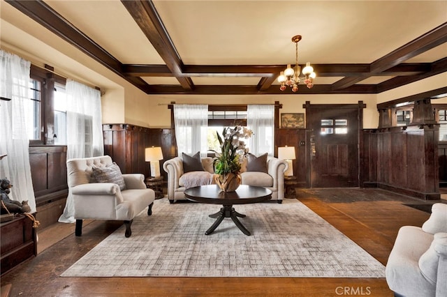 living area featuring a notable chandelier, plenty of natural light, coffered ceiling, and wainscoting