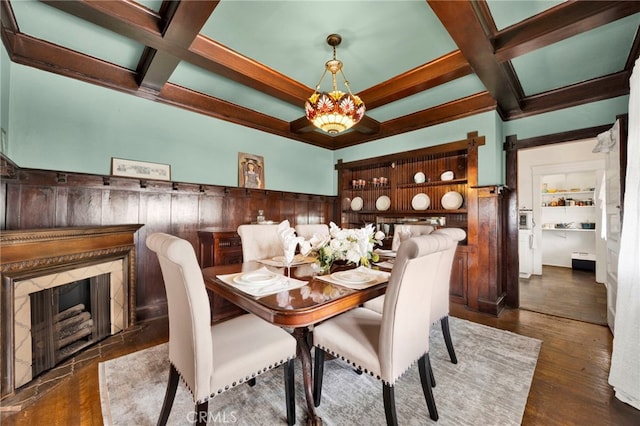 dining room featuring beam ceiling, coffered ceiling, and wood finished floors