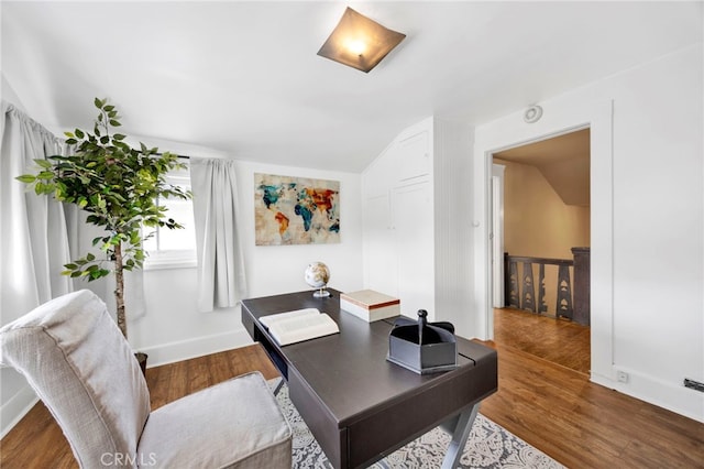 office space featuring baseboards, lofted ceiling, and wood finished floors