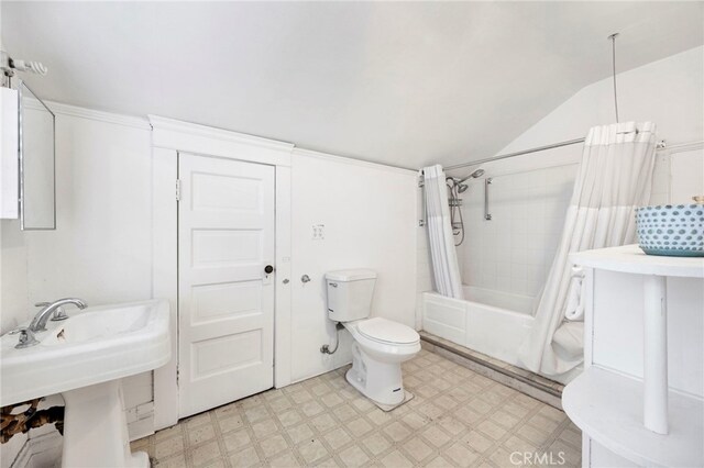 bathroom featuring tile patterned floors, toilet, shower / tub combo with curtain, a sink, and lofted ceiling