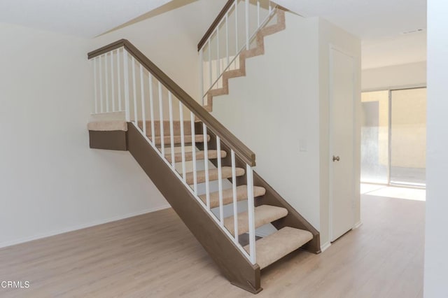 stairs with baseboards and wood finished floors