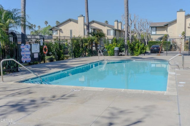 community pool featuring a residential view and fence