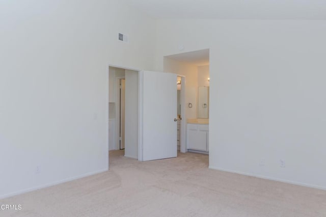 empty room featuring visible vents, light colored carpet, high vaulted ceiling, and baseboards