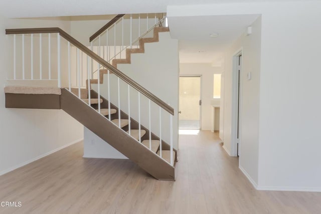 stairway featuring wood finished floors and baseboards