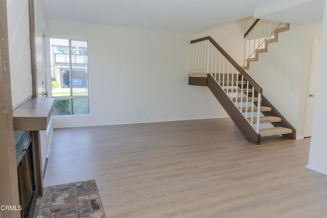 stairway featuring wood finished floors and baseboards