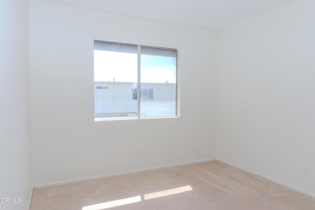 empty room with baseboards and carpet