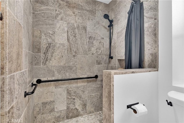 bathroom with toilet and a tile shower