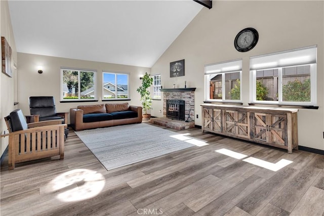 living area with wood finished floors, baseboards, beamed ceiling, high vaulted ceiling, and a brick fireplace