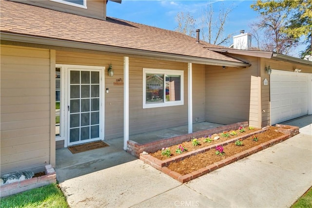 view of exterior entry featuring a garage, a porch, a chimney, and roof with shingles