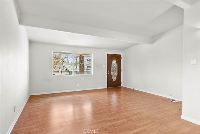 foyer with beamed ceiling, baseboards, and light wood-style floors