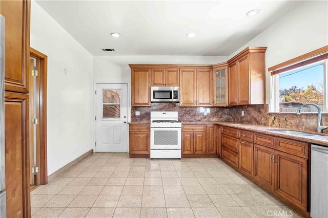 kitchen with visible vents, brown cabinets, appliances with stainless steel finishes, and a sink