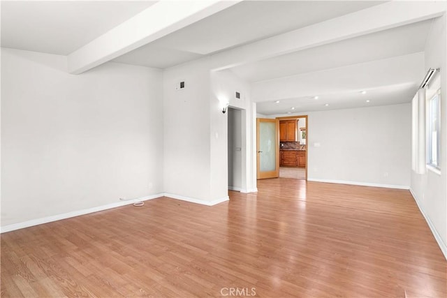 unfurnished room with recessed lighting, baseboards, beam ceiling, and light wood-style floors