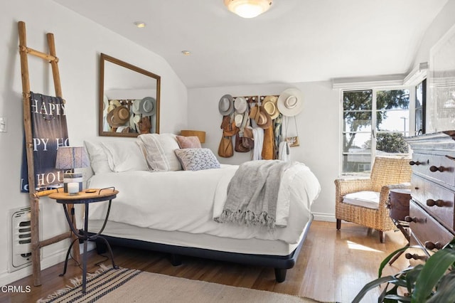 bedroom with vaulted ceiling and wood finished floors