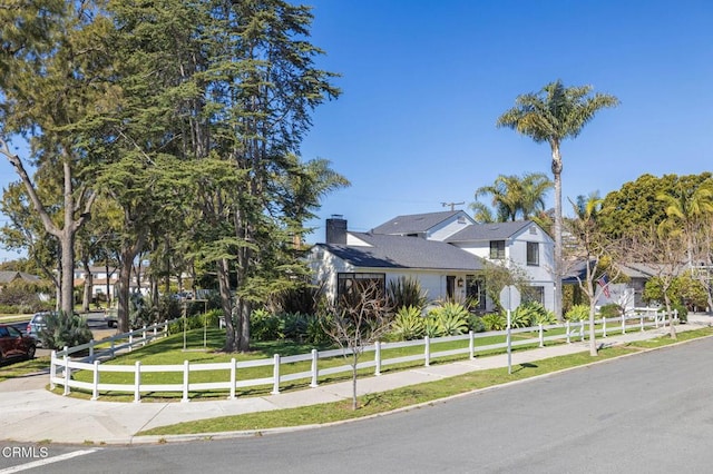 view of front of property featuring a fenced front yard, a chimney, and a front yard