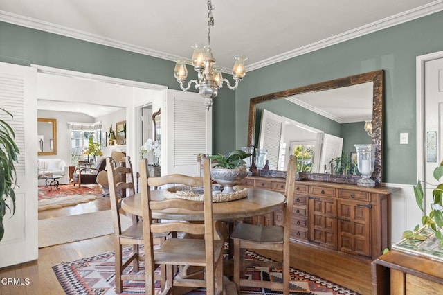 dining space featuring an inviting chandelier, wood finished floors, and ornamental molding