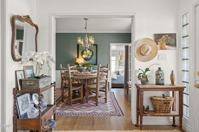 dining room featuring a notable chandelier, wood finished floors, and ornamental molding