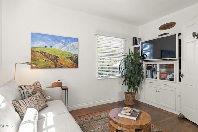 living room with dark wood-type flooring and baseboards