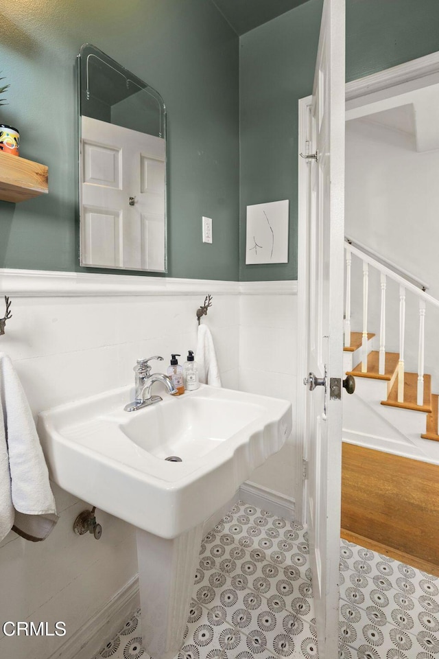 bathroom with tile patterned floors, wainscoting, and a sink