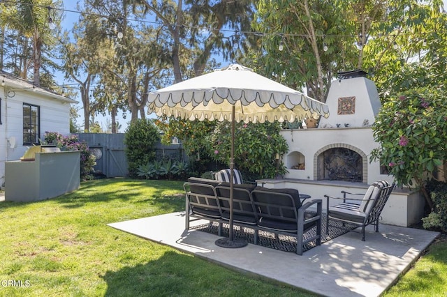 view of yard featuring an outdoor living space with a fireplace, fence, and a patio area