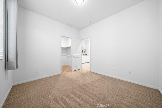 unfurnished bedroom with baseboards, visible vents, and light carpet