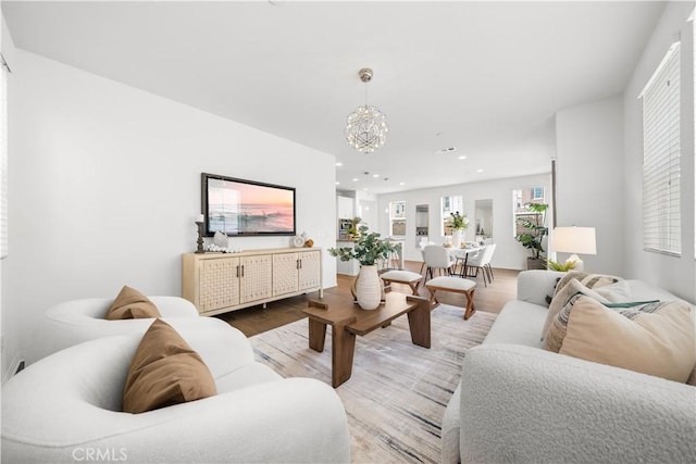 living room featuring a notable chandelier, wood finished floors, and recessed lighting