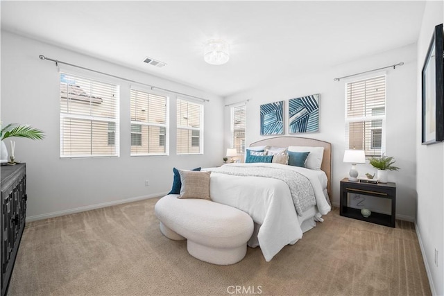 bedroom with baseboards, multiple windows, light colored carpet, and visible vents