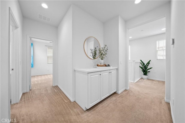 hallway with baseboards, recessed lighting, visible vents, and light carpet