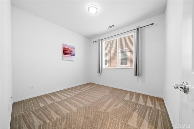 carpeted spare room with baseboards and visible vents