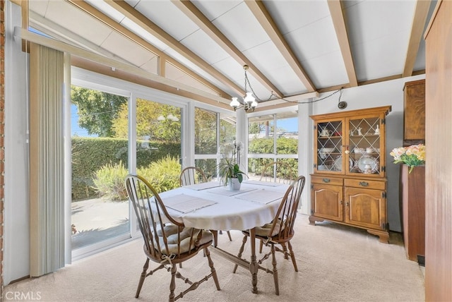 sunroom featuring lofted ceiling with beams, an inviting chandelier, and a healthy amount of sunlight