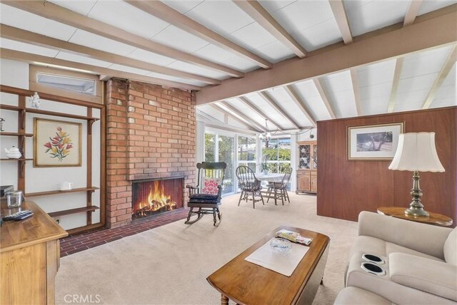 living room with carpet, vaulted ceiling with beams, wood walls, and a fireplace