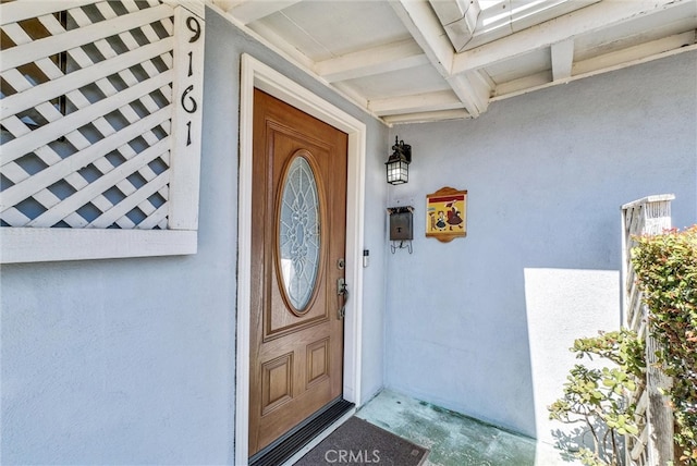 view of exterior entry featuring stucco siding