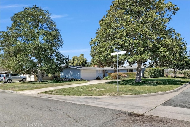 view of front facade with driveway, an attached garage, and a front lawn