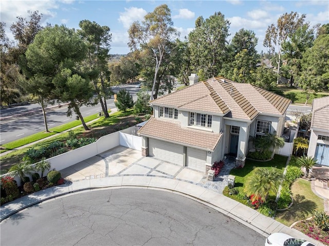 view of front of home with fence, stucco siding, concrete driveway, a garage, and a tile roof