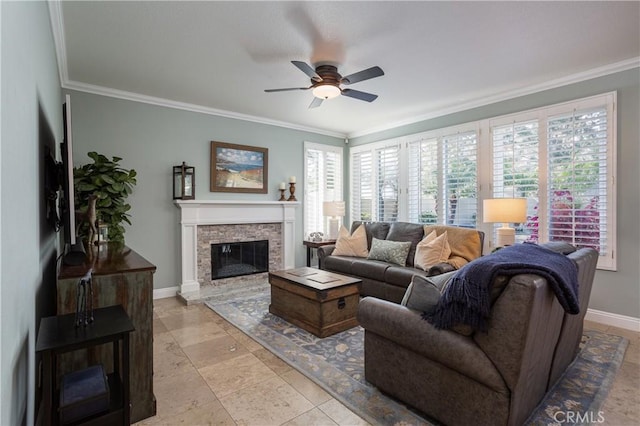 living area featuring ceiling fan, baseboards, ornamental molding, and a fireplace