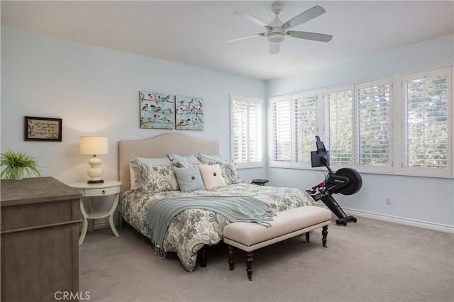 bedroom featuring baseboards, light carpet, and a ceiling fan