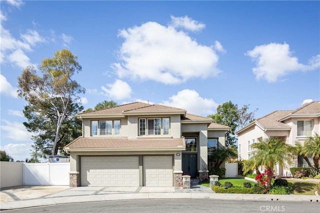 view of front of home featuring stucco siding, driveway, a tile roof, and fence