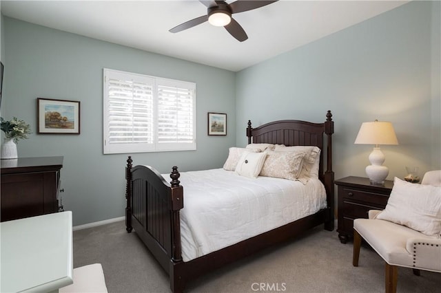 bedroom featuring baseboards, light colored carpet, and ceiling fan