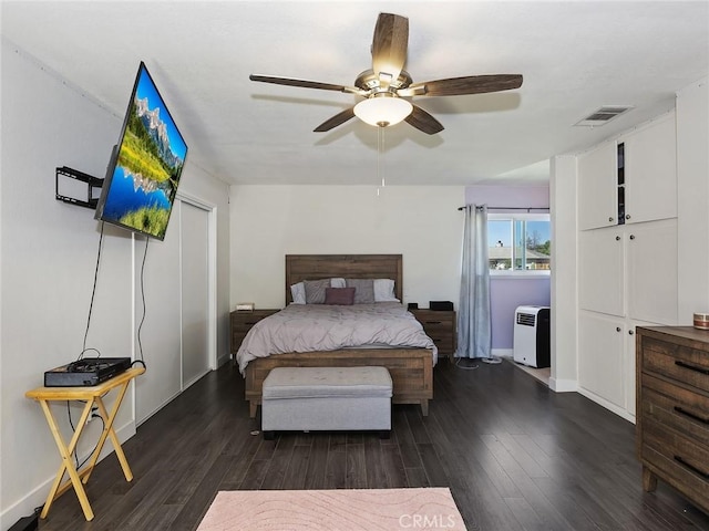 bedroom with visible vents, baseboards, wood finished floors, and a ceiling fan