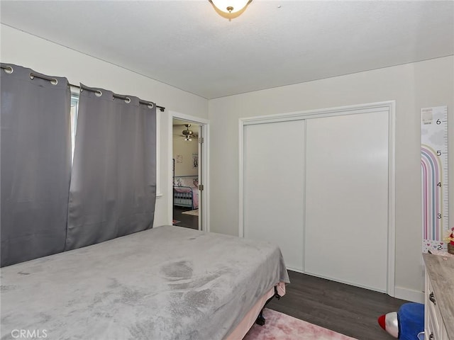 bedroom featuring a closet, a textured ceiling, and dark wood-style floors