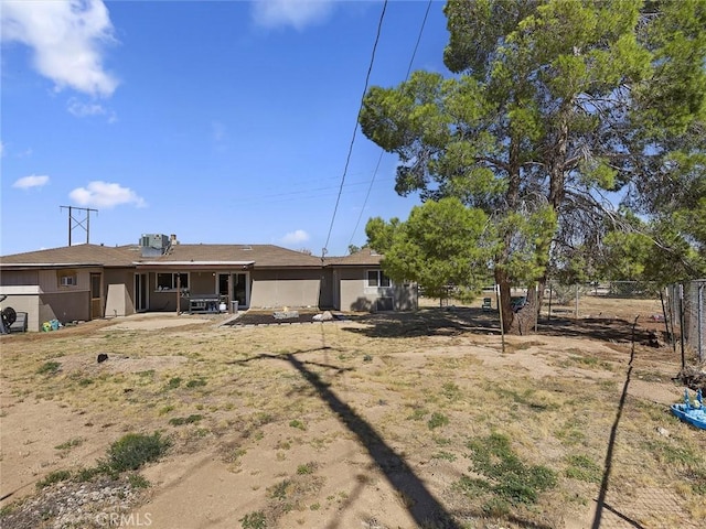 rear view of house with a patio area and fence