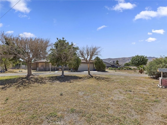 view of yard with a mountain view and a garage