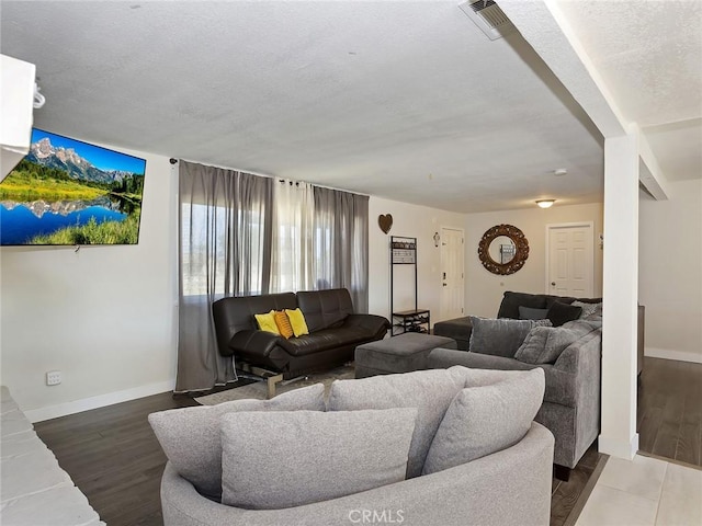 living area featuring visible vents, a textured ceiling, and wood finished floors