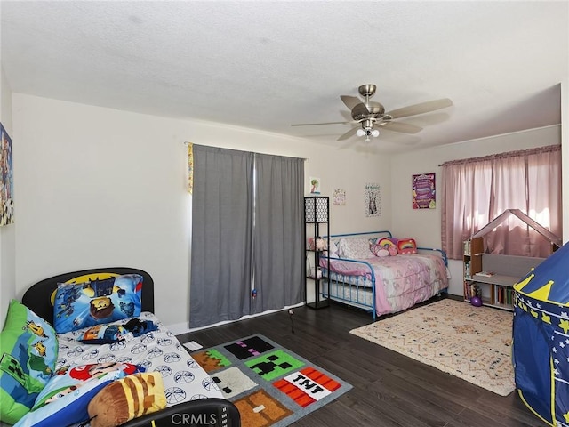 bedroom featuring ceiling fan, baseboards, a textured ceiling, and wood finished floors