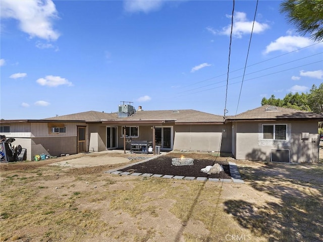 back of property with a patio and stucco siding