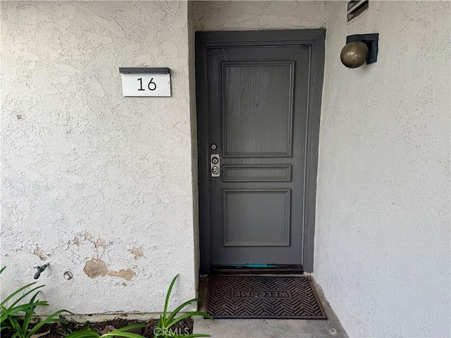 entrance to property with stucco siding